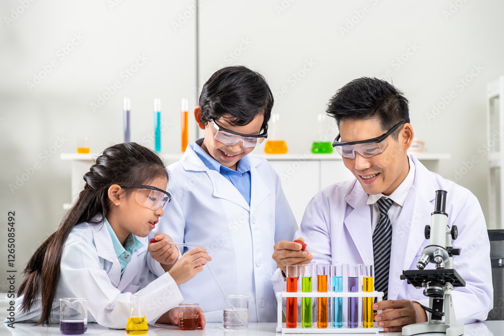 Asian boy and girl children pupils kids conducting science experiments with male teacher in laboratory class Asian boy and girl children pupils kids conducting science experiments with male teacher in laboratory class