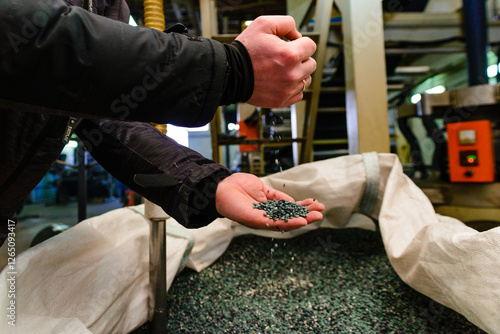 hands hold or touching biodegradable plastic pellets, plastic polymer granules