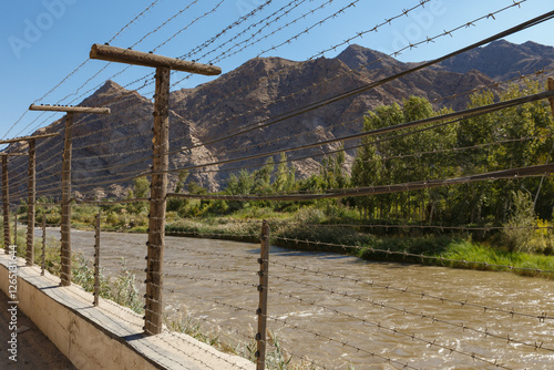 Border view between Armenia and Iran along the Aras river with a fence