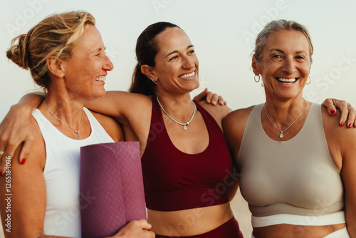 Fotografía Happy mature women embracing and smiling outdoors in yoga attire