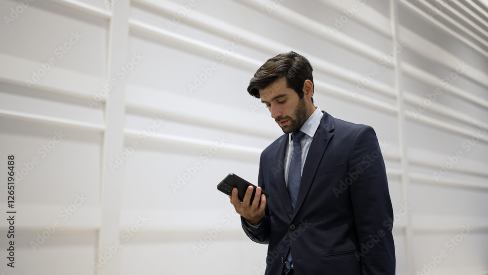 Smart manager looking at phone while standing at white background. Handsome male leader checking email or updated project and planing marketing strategy. while standing at white background. Exultant. Smart manager looking at phone while standing at white background. Handsome male leader checking email or updated project and planing marketing strategy. while standing at white background. Exultant.