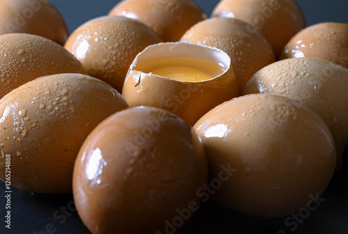Obraz na płótnie View of Egg yolk in Broken raw chicken eggshell in the among of Fresh chicken egg (Hen egg) on dark background. Natural organic fresh eggs for healthy food, use it as your Space for text, Design. w salonie