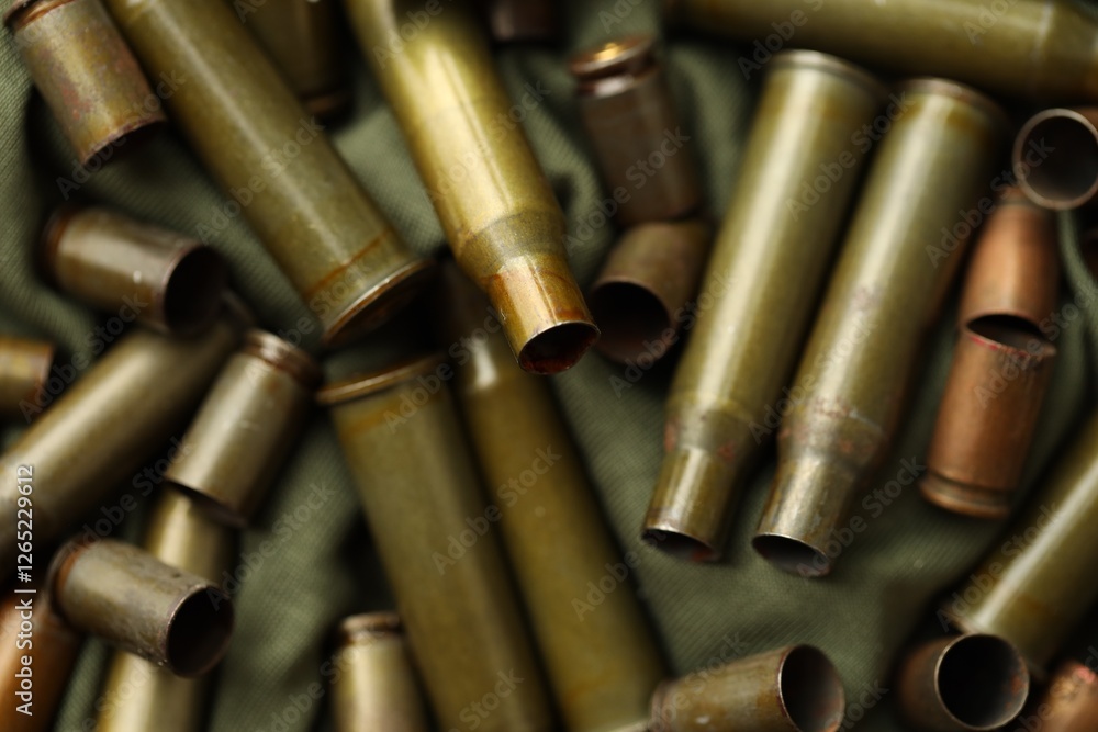 Many used rifle cartridges on military camo green fabric background Many used rifle cartridges on military camo green fabric background