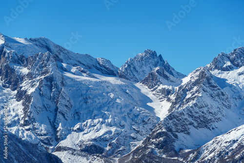 Picturesque landscape in Dombay with amazing snow-capped peaks and majestic blue slopes of North Caucasus Mountains. Mountain ski resort in Karachay-Cherkessia, Russia photo