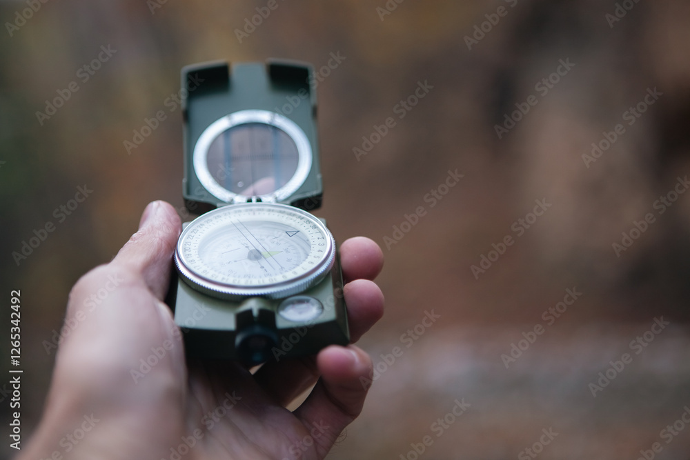 hand holding compass on a background of the forest. hand holding compass on a background of the forest.