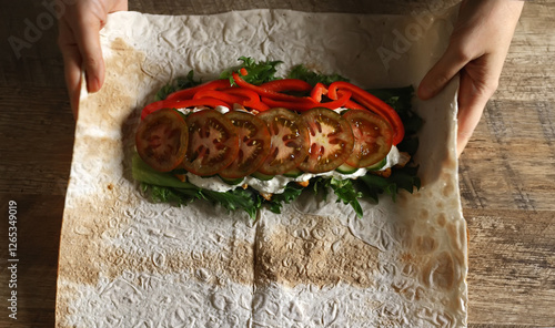 Wrapping shawarma in lavash with chicken and vegetables. photo