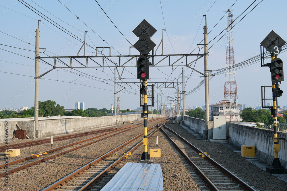 Fototapeta premium Railway Tracks with Red Traffic Signals and Overhead Power Lines