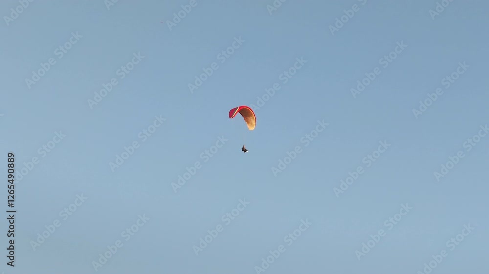 Paraglider flying above Alanya's coastline, with cityscape, hills, and Mediterranean Sea under clear skies, oe01