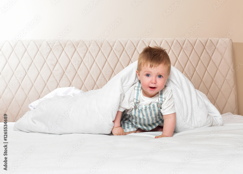 Fototapeta premium bright portrait of adorable baby. Beautiful baby in the interior. Happy cheerful baby in the interior of the bedroom. Laughter.