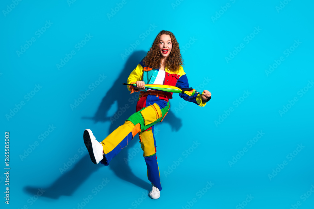 Smiling woman in colorful outfit joyfully posing on a vibrant blue background Smiling woman in colorful outfit joyfully posing on a vibrant blue background