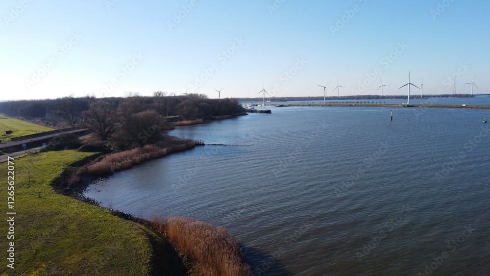 Water surface of the Dutch Delta. Hollandsdiep and Haringvliet with windmills and views over a wetland area of nature and biological environment. Sail and waterway with passage to major industry. Water surface of the Dutch Delta. Hollandsdiep and Haringvliet with windmills and views over a wetland area of nature and biological environment. Sail and waterway with passage to major industry.