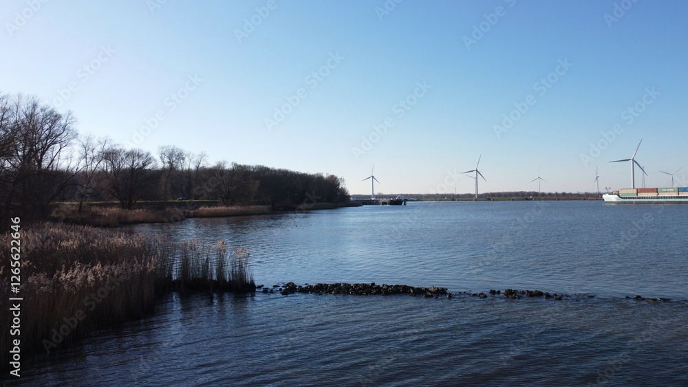 Water surface of the Dutch Delta. Hollandsdiep and Haringvliet with windmills and views over a wetland area of nature and biological environment. Sail and waterway with passage to major industry. Water surface of the Dutch Delta. Hollandsdiep and Haringvliet with windmills and views over a wetland area of nature and biological environment. Sail and waterway with passage to major industry.