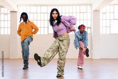 Multiethnic group of young hip hop dancers wearing colorful streetwear dancing outdoors - Stylish multiracial rap crew members meeting and having fun together