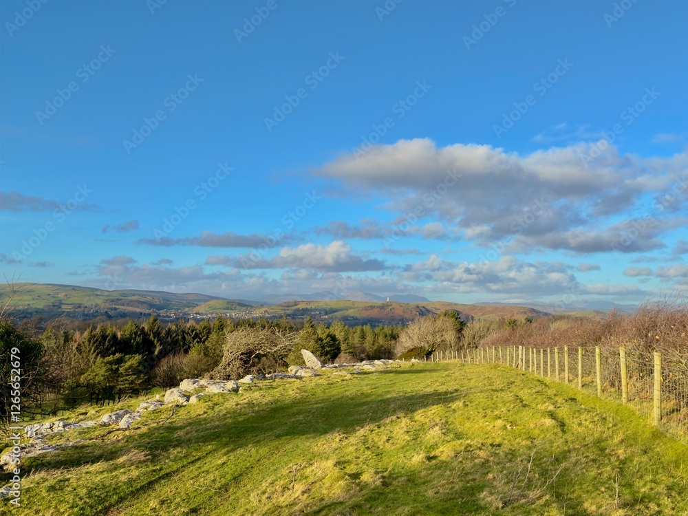 Fototapeta premium A view of rolling hills and lush countryside under a vast blue sky