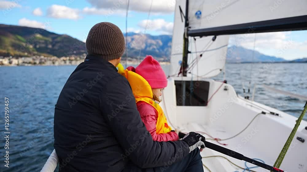 Father instructing daughter on sailing a yacht during training in the Kotor Bay, Montenegro, highlighting family bonding, adventure, and nautical sport. Father instructing daughter on sailing a yacht during training in the Kotor Bay, Montenegro, highlighting family bonding, adventure, and nautical sport.
