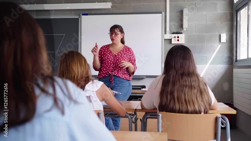 Female professor teaching in front of elementary school students in a classroom. Video with copy space.