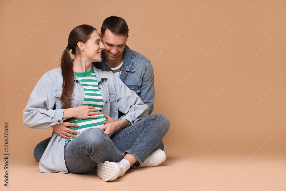 Pregnant woman and her husband on beige background. Space for text Pregnant woman and her husband on beige background. Space for text