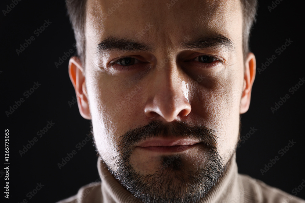 Obraz premium Sad man crying on black background, closeup