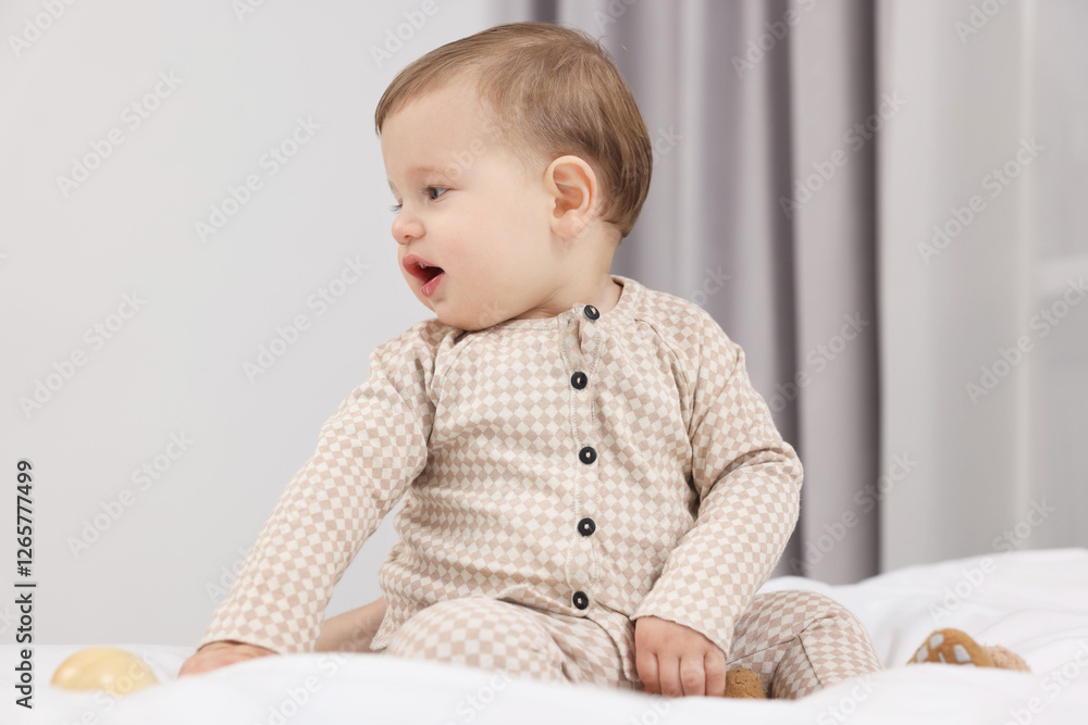 Adorable little baby with toy on bed at home Adorable little baby with toy on bed at home