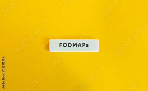 FODMAPs or Fermentable Oligosaccharides, Disaccharides, Monosaccharides And Polyols. Text on Block Letter Tile on Yellow Background. Minimal Aesthetic. photo