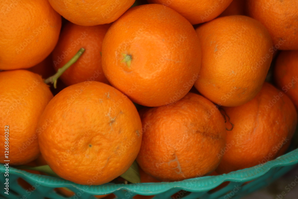 Fresh small oranges in plastic basket Fresh small oranges in plastic basket