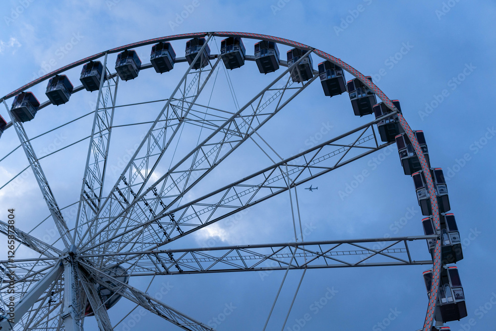 Barcelona, Spain - December 9, 2024: Large Ferris Wheel Against Cloudy Skies During Overcast Evening Barcelona, Spain - December 9, 2024: Large Ferris Wheel Against Cloudy Skies During Overcast Evening