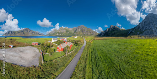 Aerial view overlooking Flakstad Church in Flakstad. In the background, the peaks of the mountains Hustinden, Digertinden, Blekktinden, and Flakstadtinden. Lofoten District in Norway photo