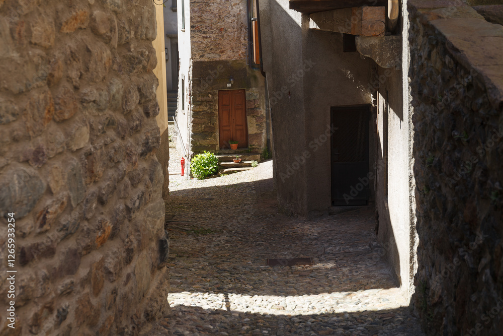 Street view of historical village with narrow cobbled streets, shot in bright summer light at Gromo, Bergamo, Lombardy, Italy