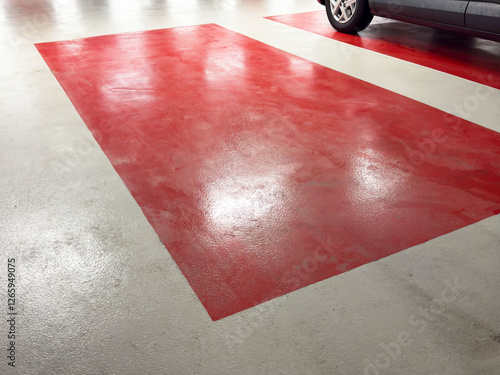 Empty parking space with red markings beside parked vehicle photo