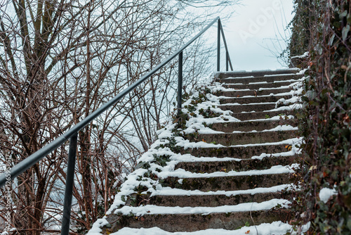 Obraz na płótnie Dangerous and slippery stairs leading up, covered with snow and moss. Leading rail guard is visible on the left. w salonie