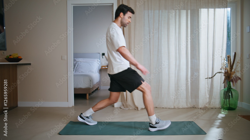 Sport man performing lunges at home workout. Sportsman practicing fitness on mat Sport man performing lunges at home workout. Sportsman practicing fitness on mat