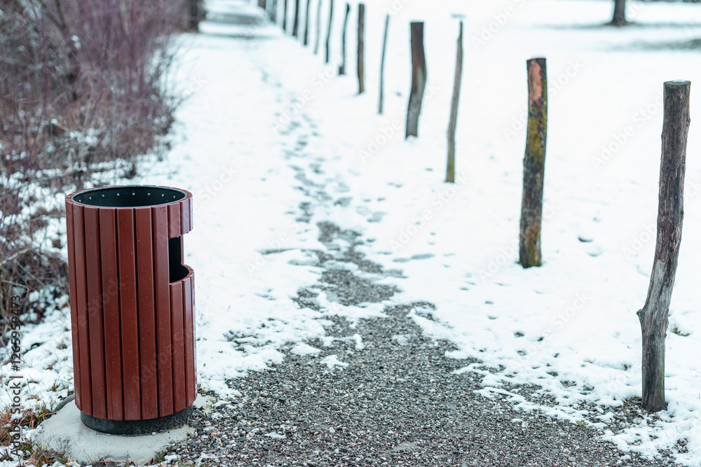 Modern wooden trashcan or trash bin next to a snowy path outdoors with visible steps.