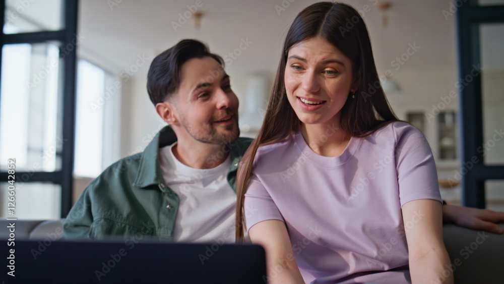 Videocalling pair speaking online talking virtual by laptop at couch closeup Videocalling pair speaking online talking virtual by laptop at couch closeup