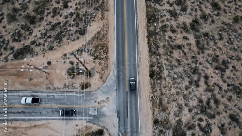 Aerial Drone Shot of a Car Driving on a Long Isolated Road at Joshua Tree National Park at Sunset