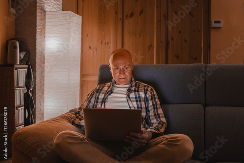 Man on the couch with laptop - online concept of distance study work.