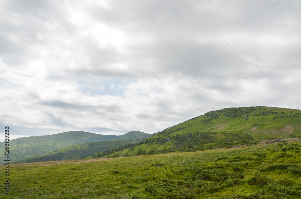 Expansive view of lush green hills under a cloudy sky, evoking tranquility and connection with nature's beauty. Svydovets, Carpathian Mountains, Ukraine Expansive view of lush green hills under a cloudy sky, evoking tranquility and connection with nature's beauty. Svydovets, Carpathian Mountains, Ukraine