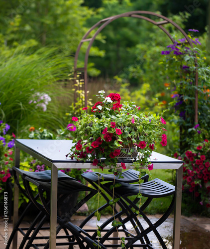 A dynamic mix of colors and textures, arrangement of vibrant pink petunias in a mint green pot on a white contemporary quartz outdoor table. A harmonious balance of bold blooms, airy grasses and color photo