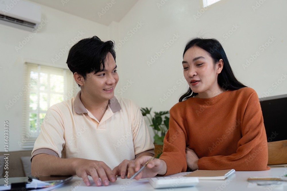 Couple reviewing expenses and calculating bills together at home, fostering teamwork. Couple reviewing expenses and calculating bills together at home, fostering teamwork.