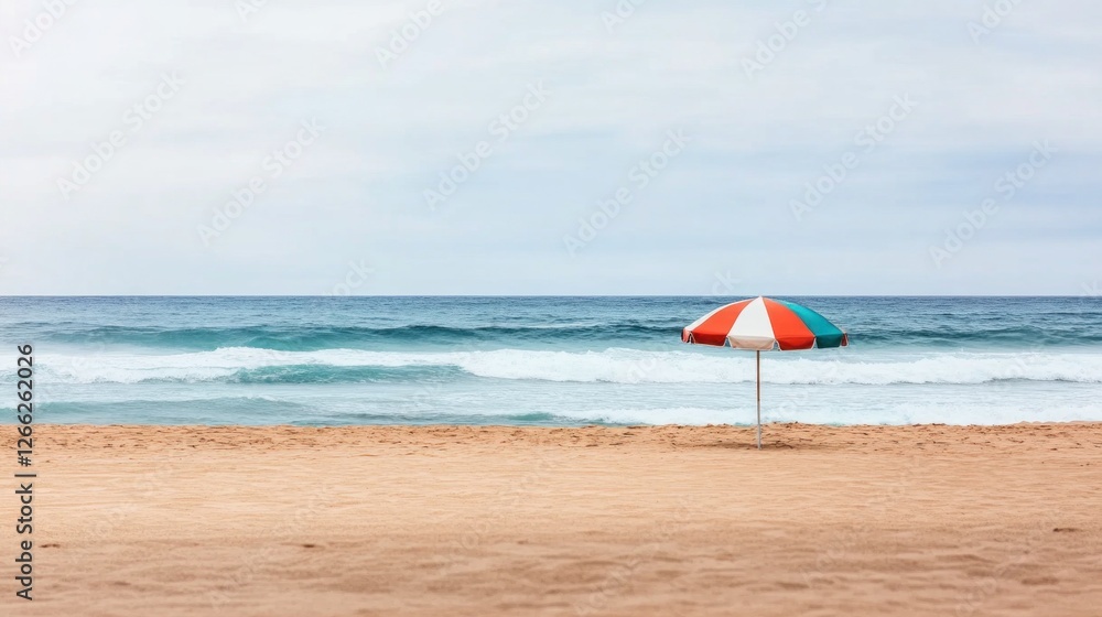A vibrant beach umbrella stands solitary on smooth golden sand, framed by gentle ocean waves under natural light A vibrant beach umbrella stands solitary on smooth golden sand, framed by gentle ocean waves under natural light