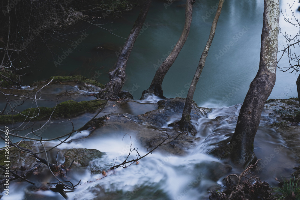 Small waterfalls in the stream flowing through the forest. Ideal for Nature and Travel Themes Small waterfalls in the stream flowing through the forest. Ideal for Nature and Travel Themes