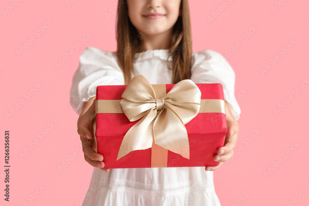 Little girl with gift on pink background, closeup Little girl with gift on pink background, closeup