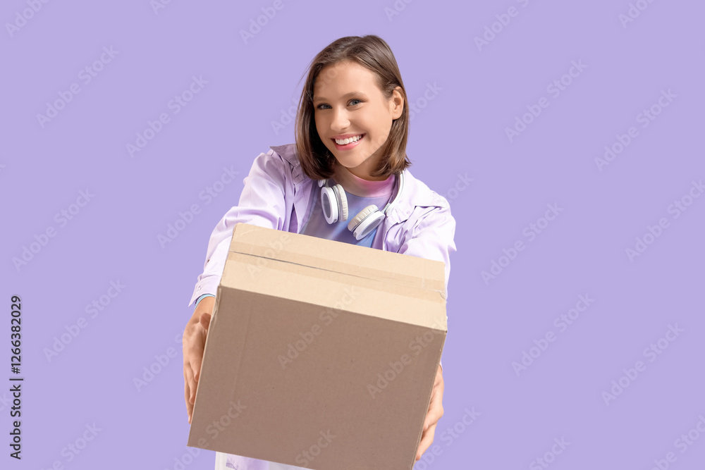 Beautiful young happy woman with parcel box and headphones on purple background