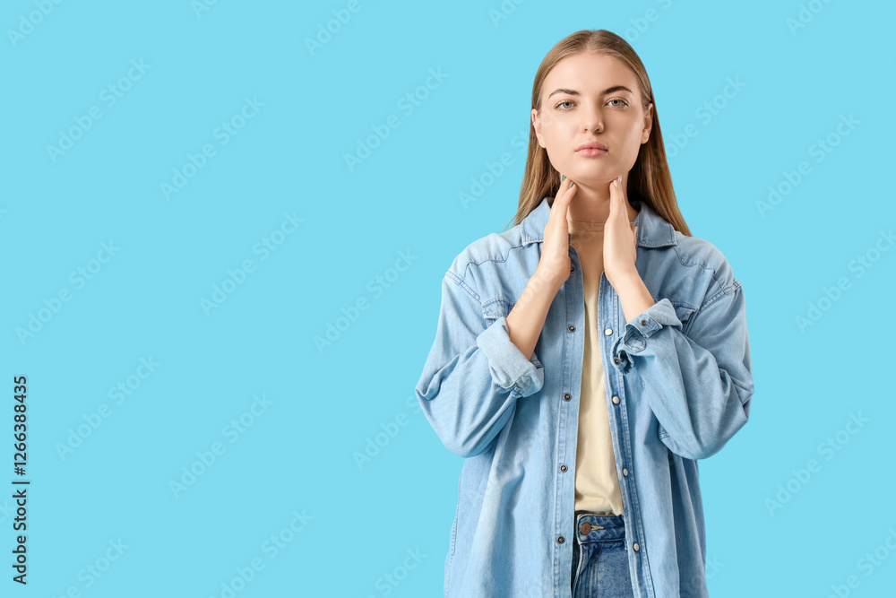 Young woman self-examining thyroid gland on blue background Young woman self-examining thyroid gland on blue background