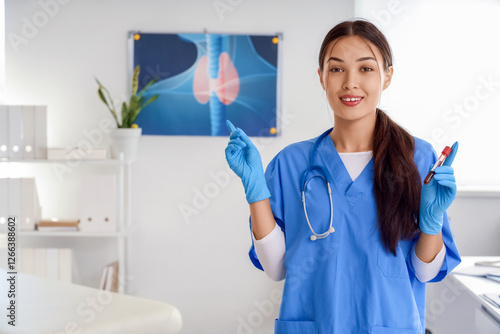 Female Asian endocrinologist with blood sample for TSH test in clinic photo