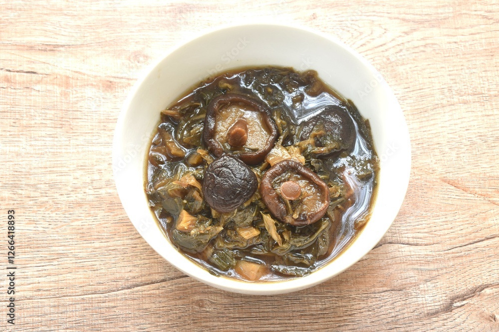 boiled chop dry salty pickled cabbage with black mushroom and slice pork belly in Chinese herb brown soup on bowl boiled chop dry salty pickled cabbage with black mushroom and slice pork belly in Chinese herb brown soup on bowl