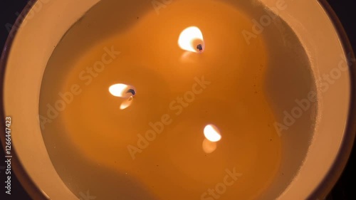 Triple wick candle from above, flames
