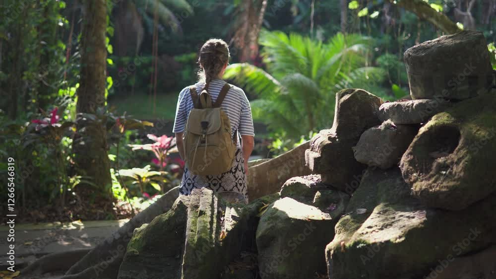 Female tourist with backpack is enjoying view of a forest Female tourist with backpack is enjoying view of a forest