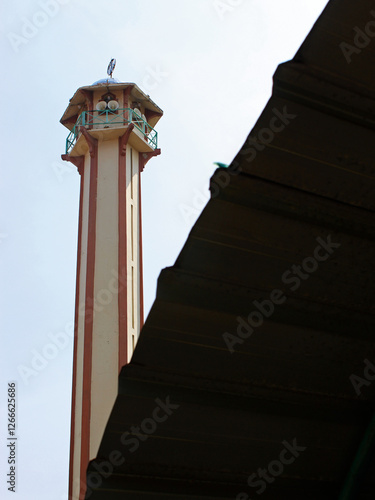 View of the mosque minaret behind the roof on a clear day.