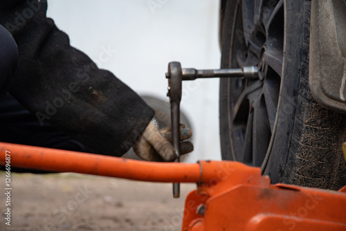 Changing a wheel. Close-up of loosening and tightening wheel bolts. Seasonal tire change. Part of the photo is blurred. The process of changing a car wheel. Close-up.