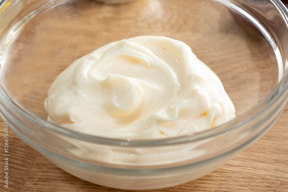 A closeup view of a glass bowl of mayonnaise. A closeup view of a glass bowl of mayonnaise.